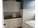 Functional laundry room with ample storage, sink, and white beadboard walls at 135 Waycross Dr, Rockwell, NC 28138