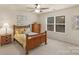 Bedroom features a dresser, natural light, neutral carpet, ceiling fan, and decorative wall art at 14104 Green Birch Dr, Pineville, NC 28134
