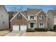 Inviting two-story brick home featuring a two-car garage and a cozy front porch at 14104 Green Birch Dr, Pineville, NC 28134