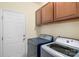 Spacious laundry room features a washer, dryer, white door, cabinets, and light yellow walls at 14104 Green Birch Dr, Pineville, NC 28134