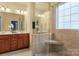 Main bathroom boasts a shower with a built-in seat, a window, vanity, and a large mirror at 14104 Green Birch Dr, Pineville, NC 28134
