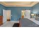 Bright main bedroom boasts an attached bathroom, white barn door, blue accent wall, and neutral carpet at 14104 Green Birch Dr, Pineville, NC 28134