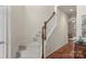 Carpeted staircase features stained wooden railing and hardwood floors in this neutrally decorated home at 14104 Green Birch Dr, Pineville, NC 28134
