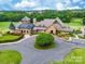 Aerial view of stunning clubhouse with stone accents, landscaped grounds, and golf course in the background at 15416 Cimarron Hills Ln, Charlotte, NC 28278