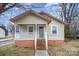 Charming single-story home featuring a cozy front porch and natural light from the large windows at 207 S Caldwell Ave, Newton, NC 28658