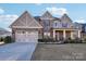 Charming two-story home with a brick and siding exterior, a two-car garage, and a well-manicured lawn at 4027 Wiltshire Ln, Indian Land, SC 29707
