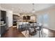 Open kitchen and breakfast nook featuring dark cabinets, granite counters, stainless appliances, and modern lighting at 4027 Wiltshire Ln, Indian Land, SC 29707