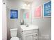 Well-lit bathroom with white vanity, framed mirror, and colorful wall art at 434 Serenity Cir # F, Cramerton, NC 28032
