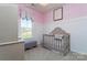 Charming Bedroom with gray crib, light pink accents, and a window view at 434 Serenity Cir # F, Cramerton, NC 28032