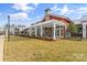 Beautiful clubhouse exterior featuring red siding, white pergola, stone fireplace, and well-maintained lawn at 473 Bowline Dr, Denver, NC 28037