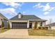Charming single-story home with a dark gray garage door, covered porch with wooden pillars, and manicured lawn at 473 Bowline Dr, Denver, NC 28037