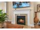 Close-up of a fireplace with stone surround and burning logs, topped with a large-screen television at 473 Bowline Dr, Denver, NC 28037