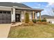 Inviting front porch with natural wood columns and stone accents, framed by green bushes and a well-maintained lawn at 473 Bowline Dr, Denver, NC 28037