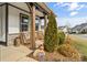 Cozy porch with wooden pillars, wicker chairs, greenery, and the house number displayed on a stone at 473 Bowline Dr, Denver, NC 28037