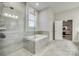Spa-like bathroom with a glass-enclosed shower, garden tub, and modern finishes at 520 Crawfish Dr, Fort Mill, SC 29708