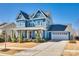 Beautiful two-story blue home with an attached garage and a well-maintained lawn and landscaping at 520 Crawfish Dr, Fort Mill, SC 29708