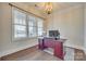 Home office with dark wood desk, hardwood floors, and lots of natural light from a large window at 520 Crawfish Dr, Fort Mill, SC 29708