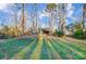 Large, grassy backyard featuring a playset, shed, and mature trees, offering privacy and space at 6017 Caroline Dr, Matthews, NC 28104