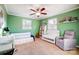 Green Bedroom with ceiling fan, two windows, daybed, crib, and rocking chair at 6017 Caroline Dr, Matthews, NC 28104