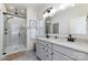 Modern bathroom with dual sink vanity, matte black hardware, framed mirror, and glass-enclosed shower at 7019 Lenton Rd, Charlotte, NC 28215
