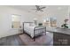 Bedroom with two windows has hardwood floors, a metal bedframe, and a ceiling fan at 7019 Lenton Rd, Charlotte, NC 28215