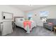 This bedroom features neutral walls, gray carpet, and natural light from two windows at 7019 Lenton Rd, Charlotte, NC 28215