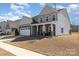 Charming two-story home featuring stone accents, covered porch, attached garage and well-manicured lawn at 7019 Lenton Rd, Charlotte, NC 28215
