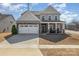 Charming two-story home with a stone and siding facade, two car garage and a well-maintained front yard at 7019 Lenton Rd, Charlotte, NC 28215