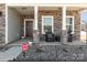 Cozy front porch with stone pillars, seating area, and views of landscaped surroundings, creating a welcoming entrance at 7019 Lenton Rd, Charlotte, NC 28215