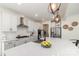 Beautiful kitchen featuring white cabinets, stainless steel appliances, a stylish light fixture, and a spacious quartz countertop island at 7019 Lenton Rd, Charlotte, NC 28215