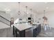 Open-concept kitchen island with stainless sink overlooks the living area and dining space at 7019 Lenton Rd, Charlotte, NC 28215