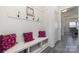Well-organized mudroom with built-in bench, storage cubbies, hooks, accent pillows, and durable flooring at 7019 Lenton Rd, Charlotte, NC 28215