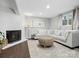 Cozy basement living area with fireplace, white sofa, and a round wicker coffee table at 7314 Entwhistle Ct, Charlotte, NC 28226