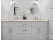 Bright bathroom with dual sinks, quartz countertop, modern fixtures, shiplap walls, and stylish mirrors at 7314 Entwhistle Ct, Charlotte, NC 28226