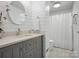 Renovated bathroom boasts gray vanity, quartz countertop, stylish mirror and shower with curtain at 7314 Entwhistle Ct, Charlotte, NC 28226