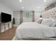 Bright bedroom features a plush bed, side tables, large window, and neutral decor at 7314 Entwhistle Ct, Charlotte, NC 28226