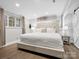 Comfortable bedroom features a large upholstered bed, hardwood floors, and soft natural light at 7314 Entwhistle Ct, Charlotte, NC 28226