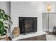 Shiplap fireplace with hearth, decorative baskets and accessories, next to a stylish floor lamp at 7314 Entwhistle Ct, Charlotte, NC 28226