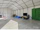 Vast metal outbuilding with concrete floors, filled with space for vehicles, and a variety of equipment at 7314 Entwhistle Ct, Charlotte, NC 28226