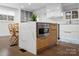 Kitchen island with marble countertop, stainless steel microwave, wooden cabinets, and stylish wooden chairs at 7314 Entwhistle Ct, Charlotte, NC 28226