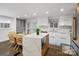 Modern kitchen with a large island, white cabinets, and stainless steel appliances, flowing into a cozy dining space at 7314 Entwhistle Ct, Charlotte, NC 28226