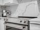 Close-up of stainless steel stove and marble backsplash in a modern, well-lit kitchen at 7314 Entwhistle Ct, Charlotte, NC 28226