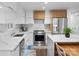 Modern kitchen features stainless steel appliances, white cabinets, and stunning marble countertops and backsplash at 7314 Entwhistle Ct, Charlotte, NC 28226