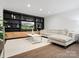 Bright living room featuring a custom built-in shelving unit, hardwood floors, and a comfortable sectional sofa at 7314 Entwhistle Ct, Charlotte, NC 28226