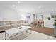 Open-concept living room with a large sectional, hardwood floors, and seamless flow into the dining area at 7314 Entwhistle Ct, Charlotte, NC 28226