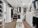 Spacious walk-in closet with custom shelving, hanging rods, shoe storage, and bench seating at 7314 Entwhistle Ct, Charlotte, NC 28226