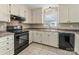 Kitchen featuring tile flooring, countertops, white cabinets, and black appliances at 7440 Apple Creek Dr, Mint Hill, NC 28227