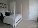 Bedroom with a four-poster bed, carpeted floor, and white doors at 8188 Normandy Rd, Denver, NC 28037