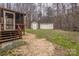 View of backyard from the screened-in porch with access stairs and storage sheds at 833 E Chestnut St, Stanley, NC 28164