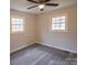 Cozy bedroom with two large windows, wood-look flooring, and a ceiling fan at 833 E Chestnut St, Stanley, NC 28164
